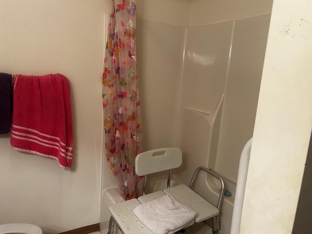 bathroom with shower / bath combination with curtain and toilet