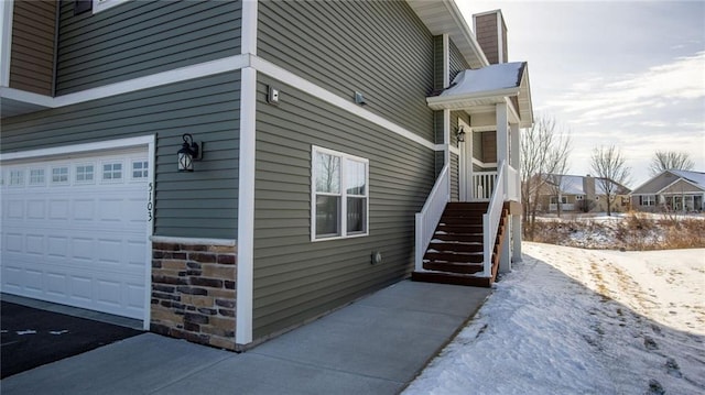 view of snowy exterior with a garage