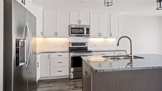 kitchen with a kitchen island with sink, sink, white cabinetry, and stainless steel appliances