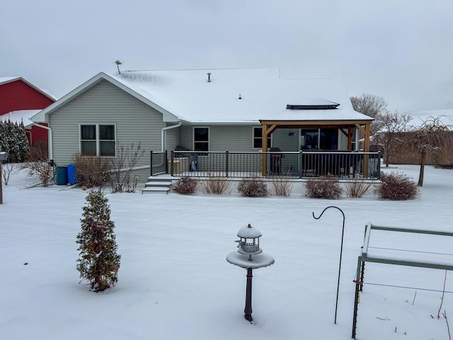 snow covered back of property with a porch