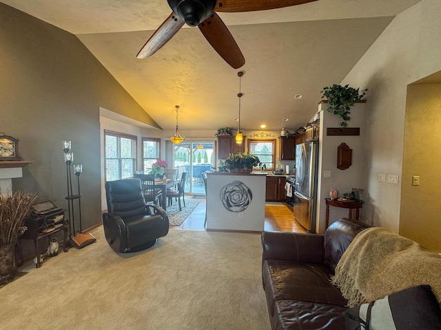 living room with ceiling fan, light colored carpet, and high vaulted ceiling