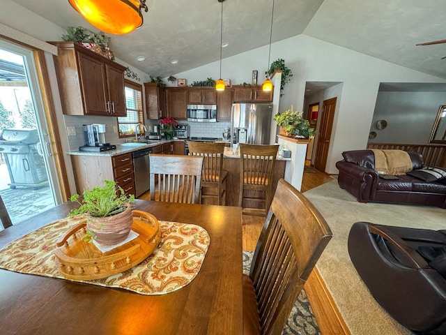 dining area with sink and vaulted ceiling