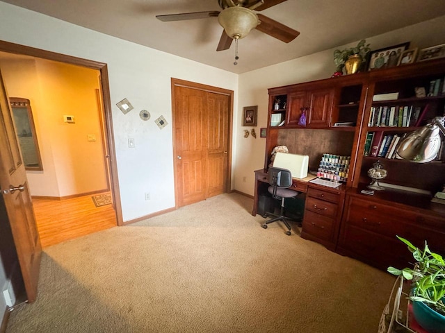 carpeted office space with ceiling fan