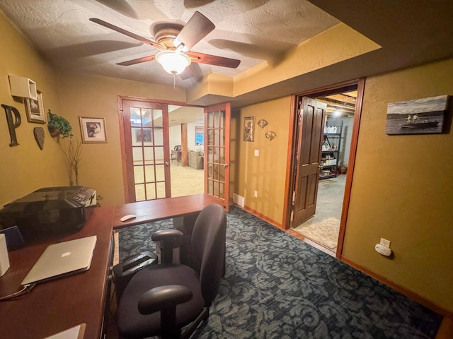 carpeted office space featuring french doors, ceiling fan, and a textured ceiling