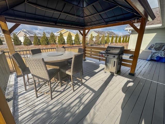 wooden terrace with a gazebo and a grill