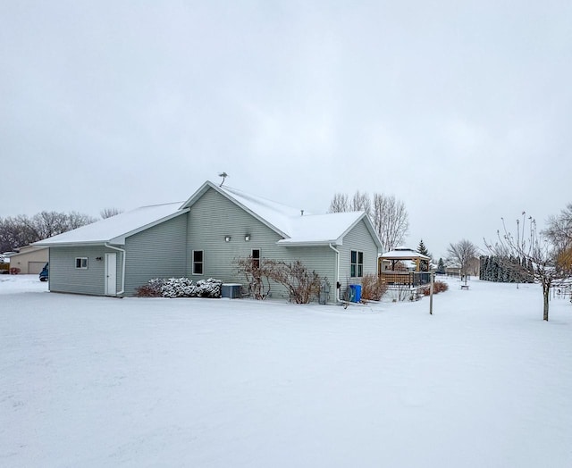 snow covered house featuring a gazebo and central AC unit