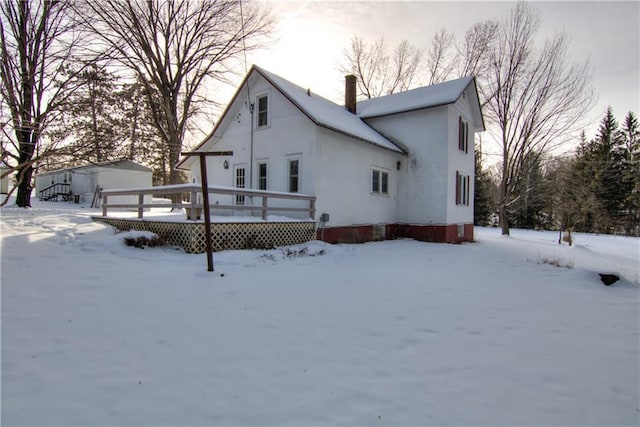 snow covered property with a deck