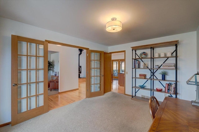 carpeted home office with french doors