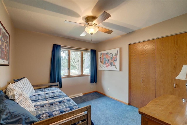 carpeted bedroom featuring baseboard heating, ceiling fan, and a closet