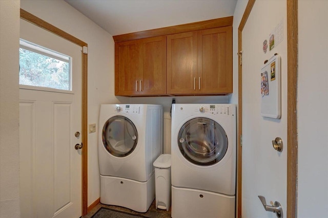 clothes washing area with cabinets and washing machine and dryer