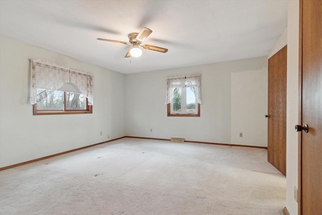 unfurnished room featuring light carpet and ceiling fan