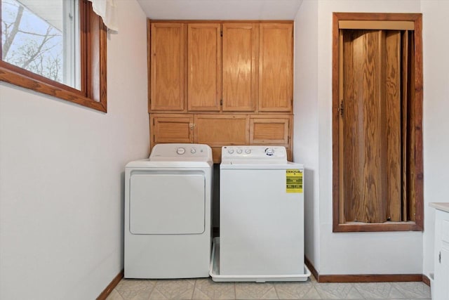 laundry area with washing machine and dryer and cabinets