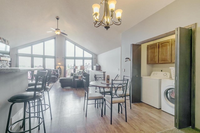 dining room with lofted ceiling, ceiling fan with notable chandelier, light hardwood / wood-style floors, and washer and dryer