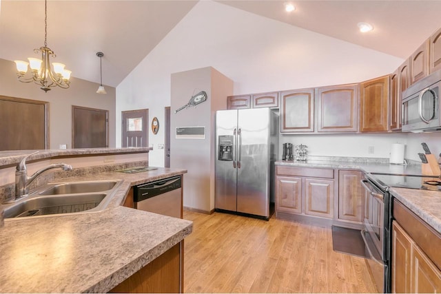 kitchen featuring sink, high vaulted ceiling, light wood-type flooring, appliances with stainless steel finishes, and pendant lighting