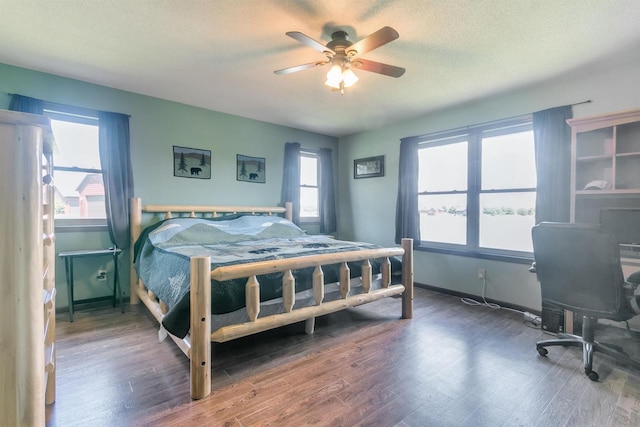 bedroom with ceiling fan, a textured ceiling, and dark hardwood / wood-style flooring