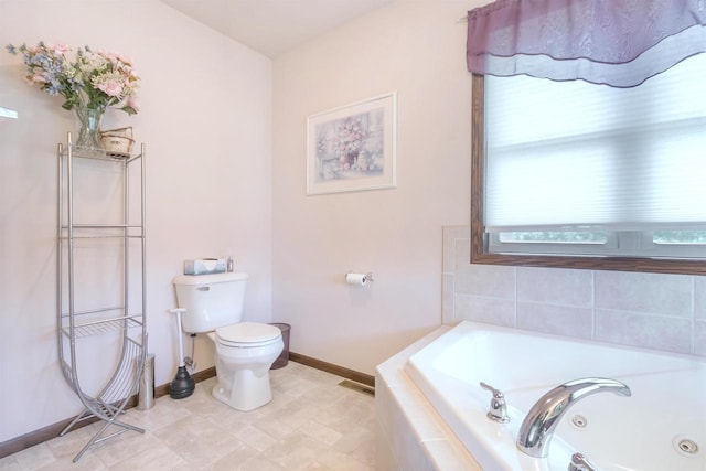 bathroom with toilet and tiled bath