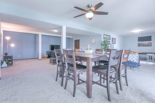 carpeted dining room with ceiling fan