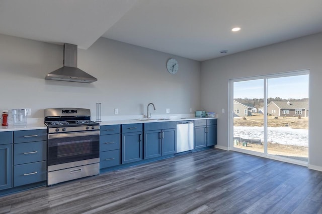 kitchen featuring dark wood-type flooring, stainless steel appliances, sink, and wall chimney range hood