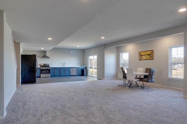 living room featuring sink, plenty of natural light, and light colored carpet