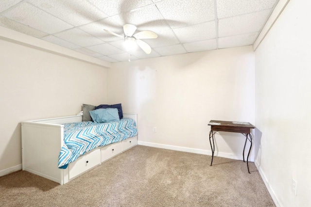 carpeted bedroom featuring a drop ceiling and ceiling fan