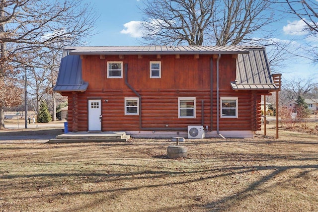 rear view of property with ac unit and a lawn