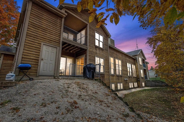 property exterior at dusk with a balcony