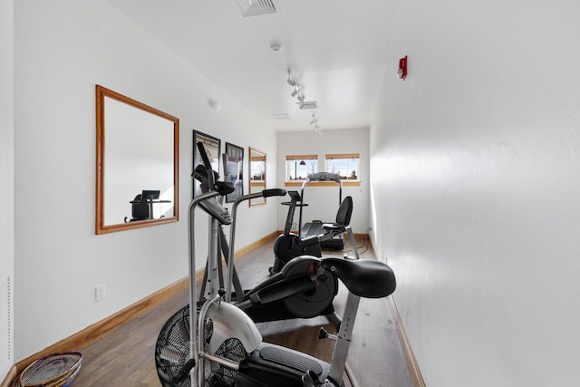 workout area featuring hardwood / wood-style floors and track lighting