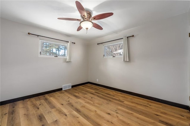 empty room with ceiling fan, a healthy amount of sunlight, and light wood-type flooring