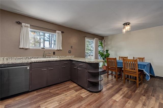 kitchen featuring dishwashing machine, sink, dark brown cabinetry, light stone countertops, and dark hardwood / wood-style flooring