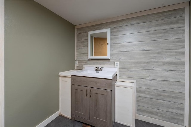 bathroom featuring vanity and wood walls