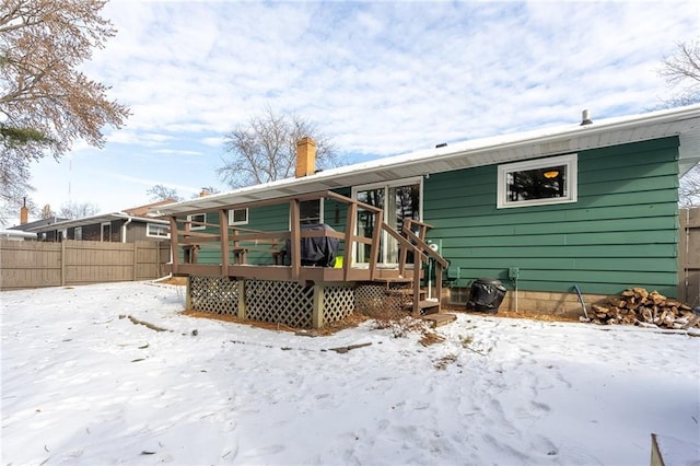 snow covered house featuring a wooden deck