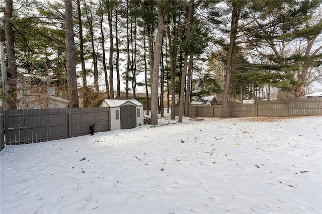 yard covered in snow featuring a storage shed