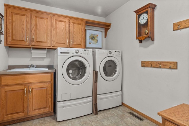 laundry room with sink, washer and clothes dryer, and cabinets