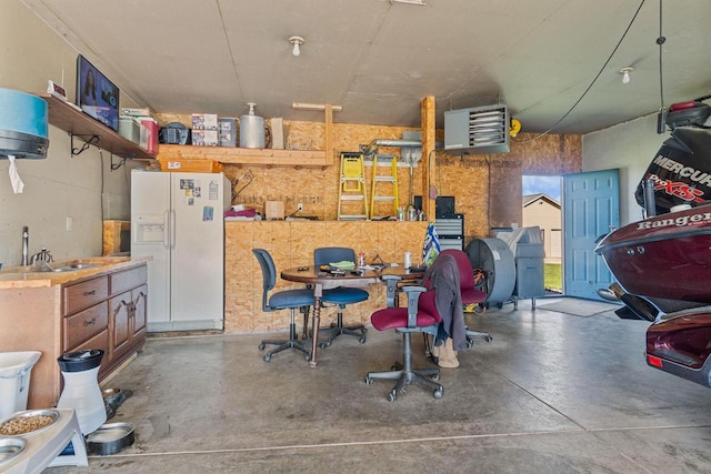 garage with sink and white fridge with ice dispenser