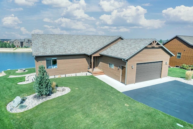 ranch-style home featuring a garage, a front yard, and a water view