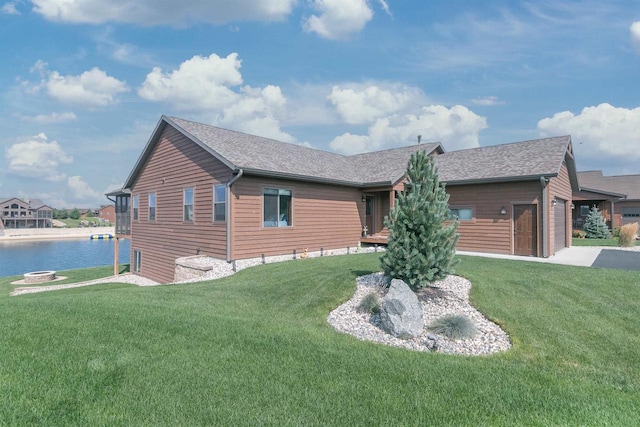 exterior space featuring a lawn and a water view