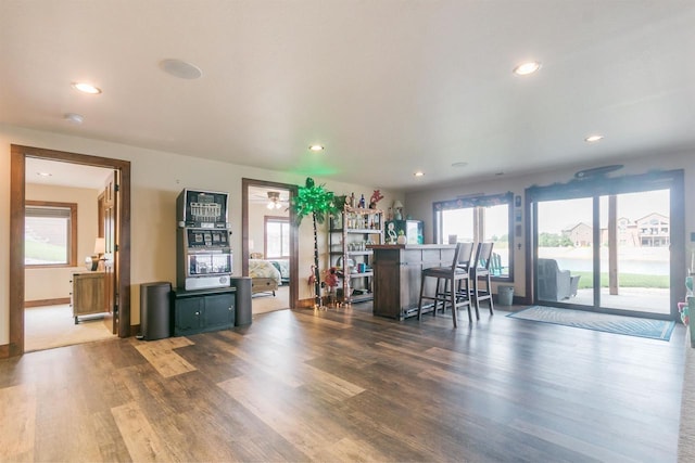 unfurnished dining area with bar, dark hardwood / wood-style flooring, and a wealth of natural light