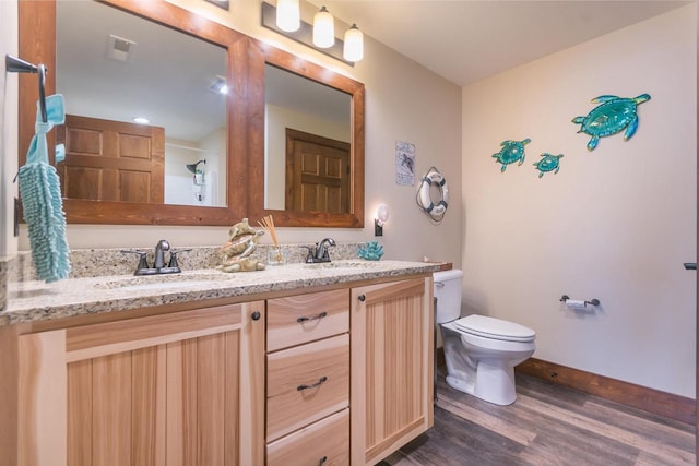 bathroom featuring vanity, wood-type flooring, and toilet