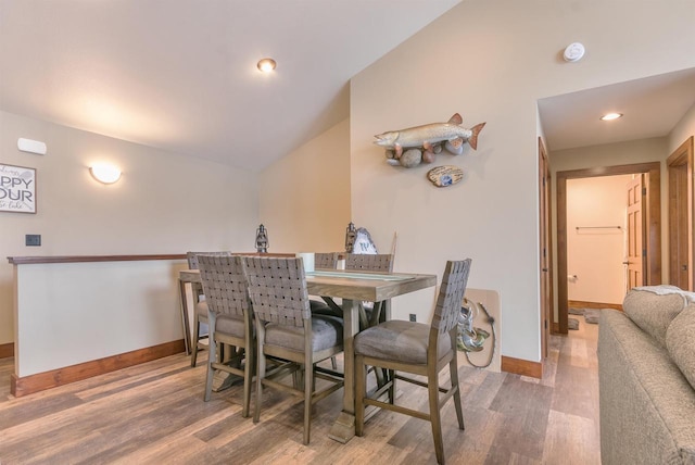 dining space with lofted ceiling and hardwood / wood-style floors