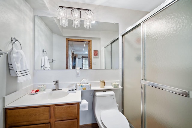 bathroom featuring vanity, toilet, and a shower with shower door