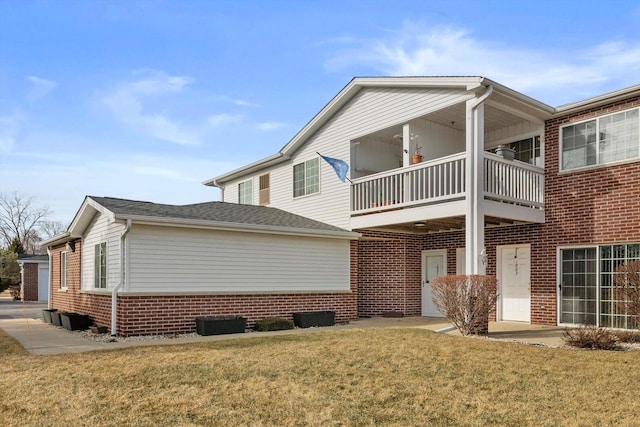 view of side of property with a balcony and a yard