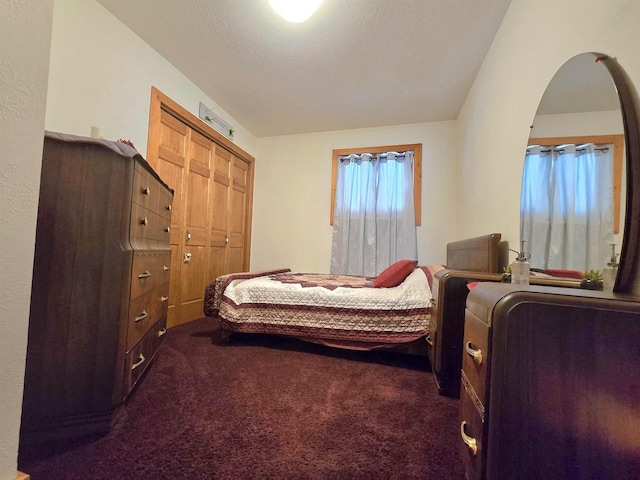 carpeted bedroom featuring a closet and a textured ceiling