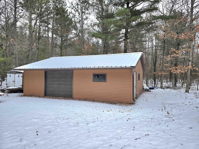 snow covered structure with a garage