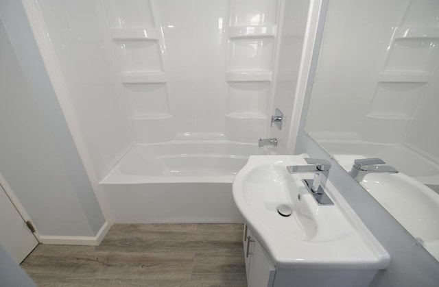 bathroom featuring hardwood / wood-style flooring, vanity, and bathing tub / shower combination