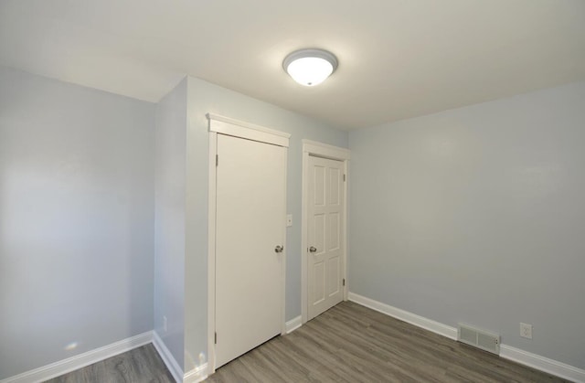 unfurnished room with hardwood / wood-style flooring