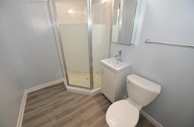 bathroom with vanity, toilet, hardwood / wood-style floors, and walk in shower