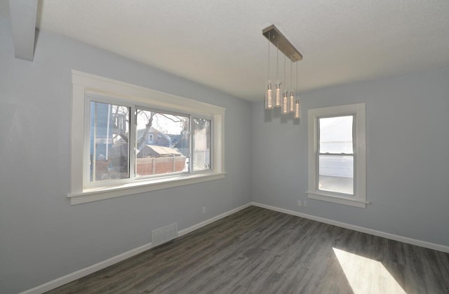 empty room featuring dark wood-type flooring and a textured ceiling