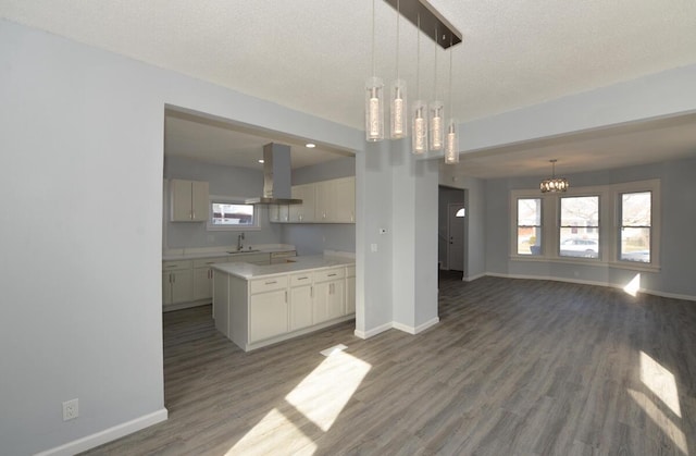 kitchen with sink, hanging light fixtures, island range hood, and a center island