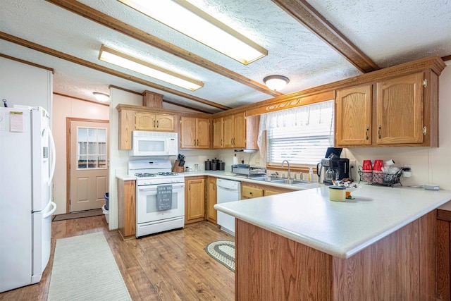 kitchen with lofted ceiling, sink, white appliances, kitchen peninsula, and light wood-type flooring