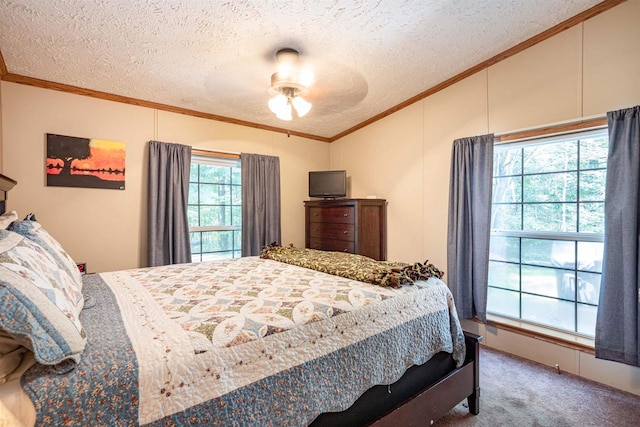 carpeted bedroom featuring ornamental molding, ceiling fan, and a textured ceiling